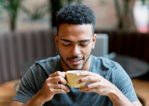 Portrait of a happy man drinking a cup of coffee at a cafe
