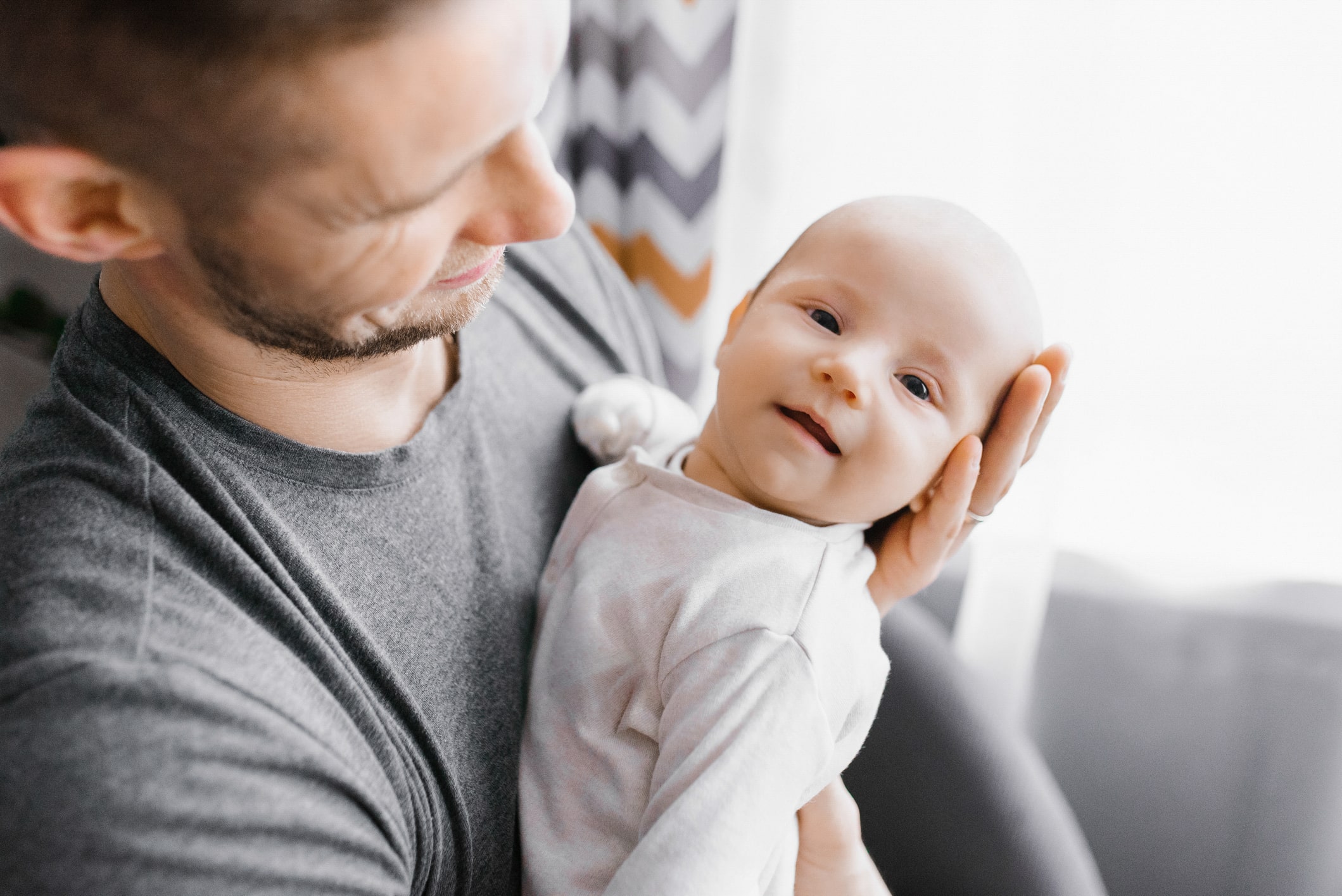 Happy dad holding newborn.